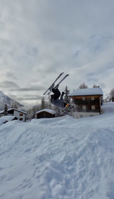Backflip auf Ski über einem Chalet